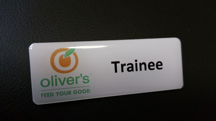 White domed name badge with logo